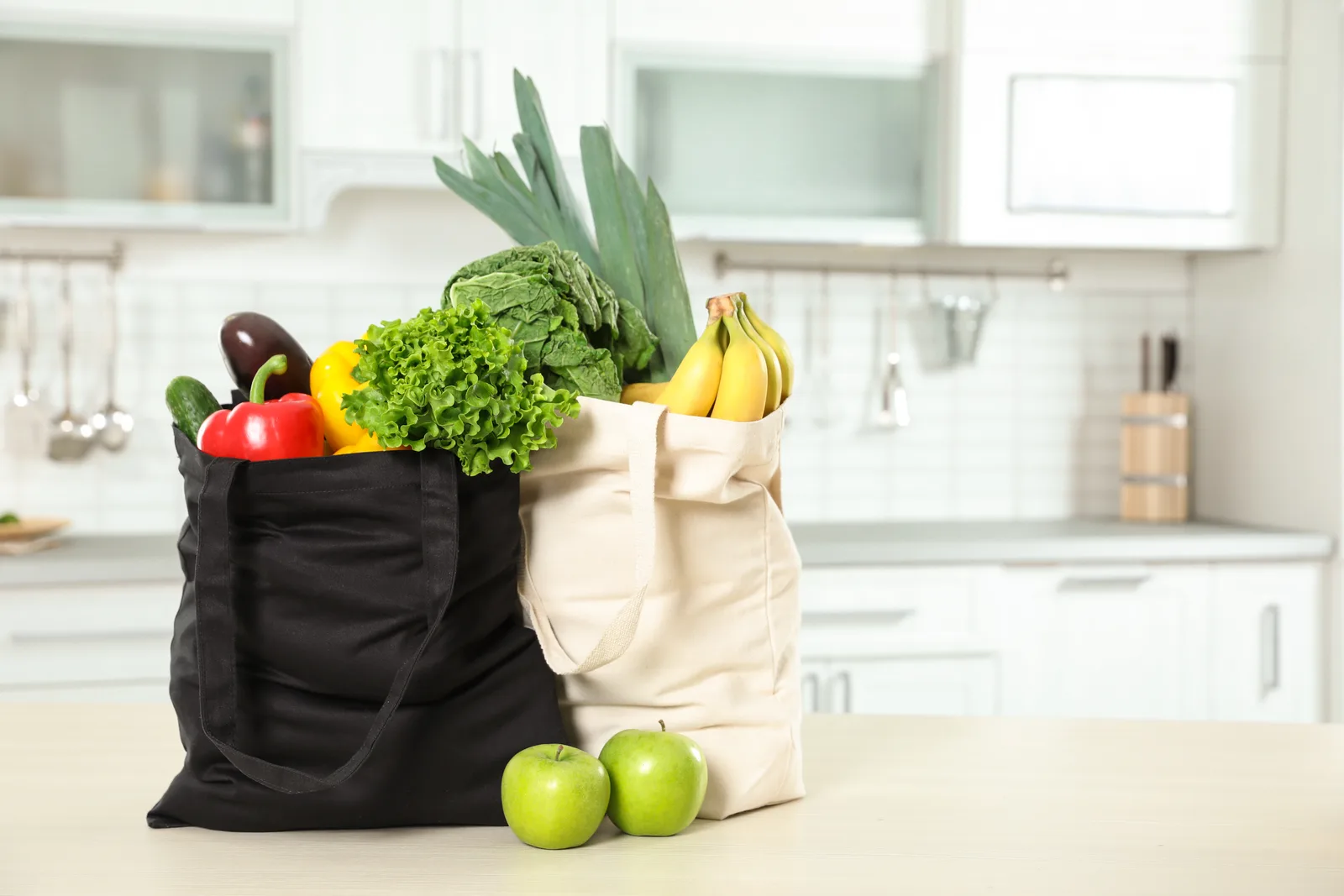 Reusable grocery bags filled with fresh groceries